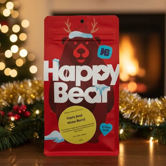 Red package of 'Happy Bear' with a festive background featuring a Christmas tree and fireplace.